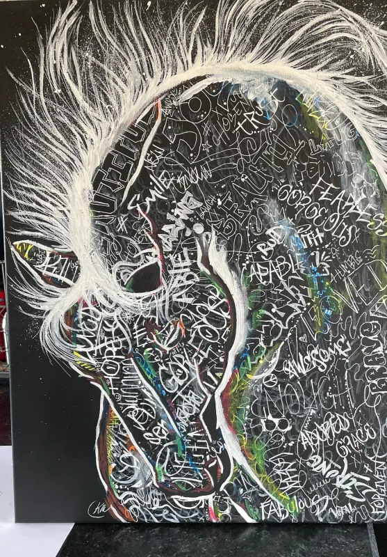 Horse made of handwritten white words such as fearless, loved and brave on black, painting by Kayla Hixon